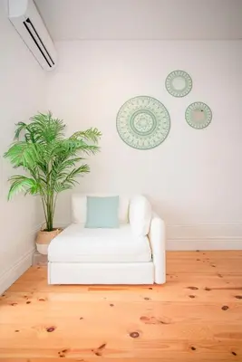 a white couch in a living room with a plant at Liiiving in Porto - Downtown Balcony Studio in Porto