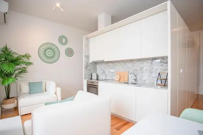 a kitchen and living room with white furniture and a counter at Liiiving in Porto - Downtown Balcony Studio in Porto