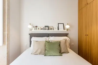 a bedroom with a bed with white sheets and pillows at Mouzinho Darling 1BR w/ AC in City Center by LovelyStay in Porto