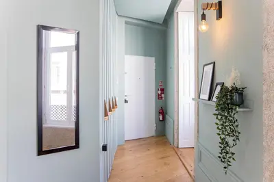 a hallway with a mirror and a door at Mouzinho Darling 1BR w/ AC in City Center by LovelyStay in Porto