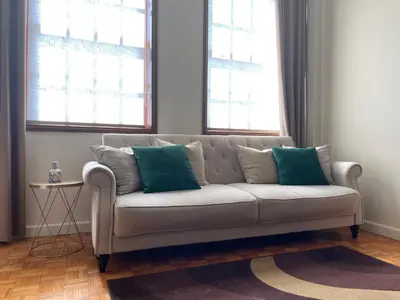 a white couch with two blue pillows in a living room at Invicta Republica Studio in Porto