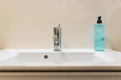 a bathroom sink with a soap bottle on it at NorteSoul Porto à Vista in Vila Nova de Gaia