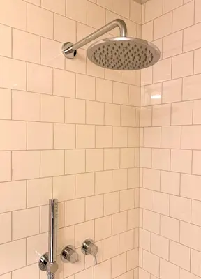 a white tiled shower with a shower head at Oporto CoLiving Monte Ramalde in Porto