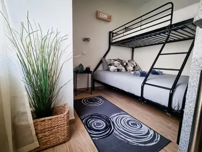 a bedroom with a bunk bed and a rug at Cantinho do Chico in Vila Nova de Gaia
