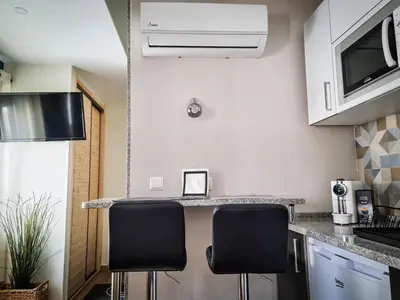 a kitchen with two black chairs at a counter at Cantinho do Chico in Vila Nova de Gaia