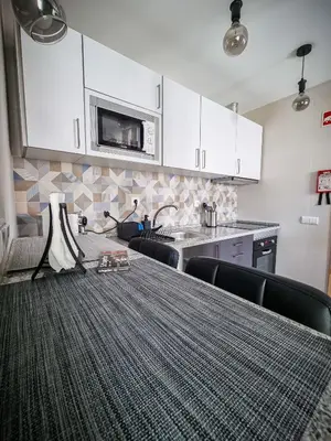 a kitchen with a table with chairs and a microwave at Cantinho do Chico in Vila Nova de Gaia