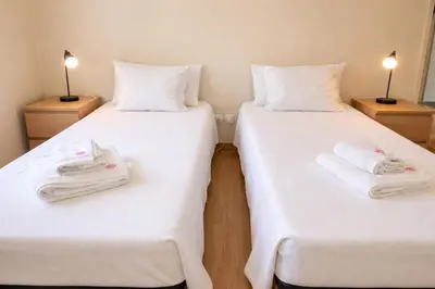 two beds in a room with white sheets and towels at Porto à Vista in Vila Nova de Gaia