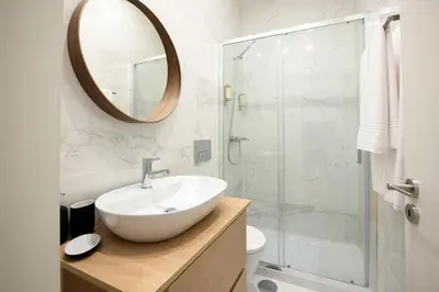 a bathroom with a sink and a shower with a mirror at North Side in Porto