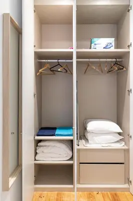 a walk in closet with white shelves at North Side in Porto