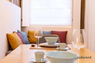 a table with glasses and plates and bowls on it at Stylish Triplex next to Ribeira in Porto