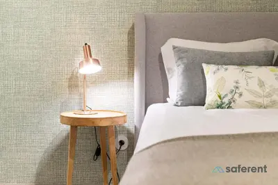 a bed with a lamp on a table next to it at Stylish Triplex next to Ribeira in Porto