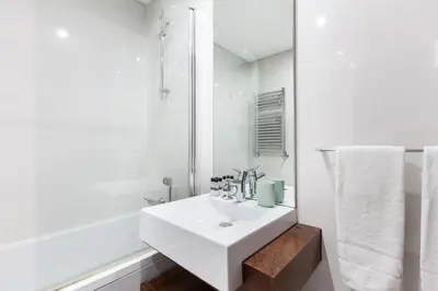 a white bathroom with a sink and a shower at D&S - Family Apartments II in Porto