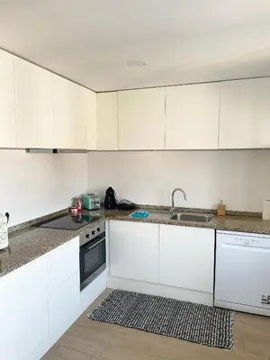 a white kitchen with white cabinets and a sink at Portoo Blue Apartments - Douro in Vila Nova de Gaia