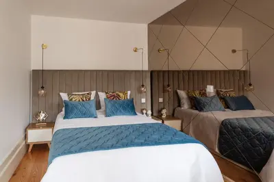 a bedroom with two beds with blue pillows at Douro Golden Studio in Porto