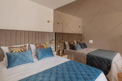 a hotel room with two beds and a mirror at Douro Golden Studio in Porto