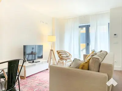 a living room with a couch and a television at The Wondrous Central Apartment in Porto