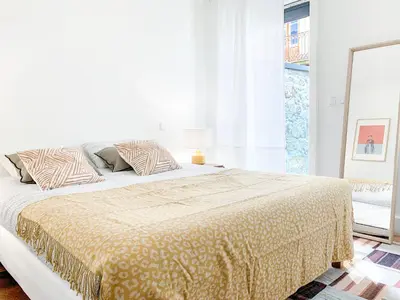 a white bedroom with a large bed and a window at The Wondrous Central Apartment in Porto