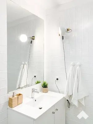 a white bathroom with a sink and a mirror at The Wondrous Central Apartment in Porto