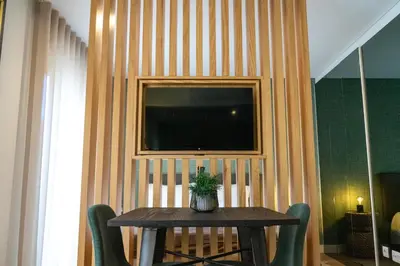 a table with chairs and a television on a wall at The Beautiful Ones Studio in Porto