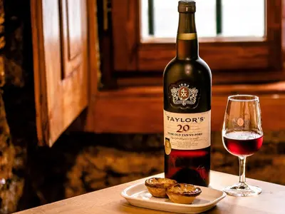 a bottle of wine next to a glass of red wine at The Beautiful Ones Studio in Porto