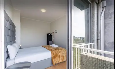 a small bedroom with a bed and a balcony at Silver Duque in Porto