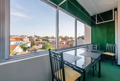 a balcony with a table and chairs and a large window at Silver Duque in Porto