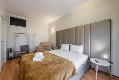 a hotel room with a large bed and a chair at Silver Duque in Porto
