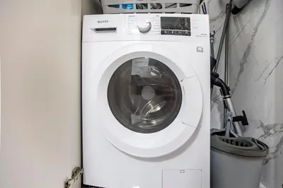 a white washing machine in a room with a trash can at Mouzinho Darling Studio w/ AC in City Center by LovelyStay in Porto