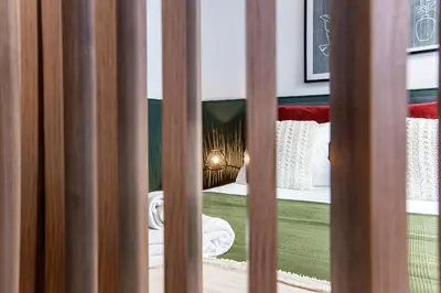 a view of a bed through a barred window at Mouzinho Darling Studio w/ AC in City Center by LovelyStay in Porto