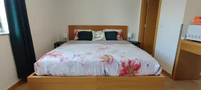 a bedroom with a bed with a floral bedspread at Get Cozy in Porto