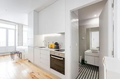 a kitchen with white cabinets and a sink at Flux Art Studio w/ AC & Balcony by LovelyStay in Porto