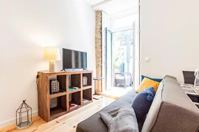 a living room with a couch and a tv at Central Studio with Pool & Patio by LovelyStay in Porto