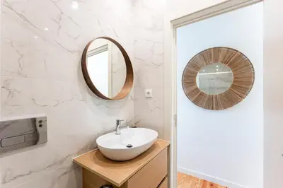 a bathroom with a sink and a mirror at Central Studio with Pool & Patio by LovelyStay in Porto