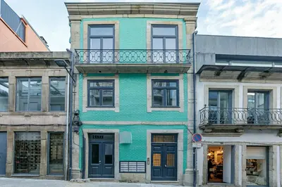 a green building with a balcony on a street at Central Studio with Pool & Patio by LovelyStay in Porto