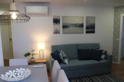 a living room with a blue couch and a table at 3 Bedrooms Central Apartment with garage by Great&Cosy in Porto