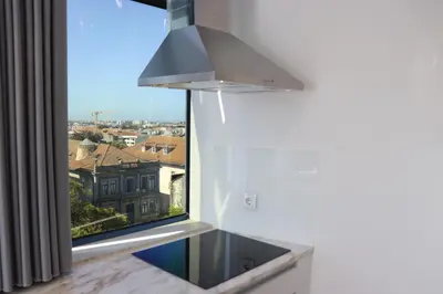 a kitchen with a window with a view of a building at 3 Bedrooms Central Apartment with garage by Great&Cosy in Porto