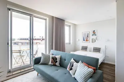 a living room with a couch and a bed at Elegant Studio w/ AC & Balcony by LovelyStay in Porto