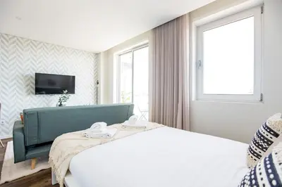 a hotel room with a bed and a television at Elegant Studio w/ AC & Balcony by LovelyStay in Porto