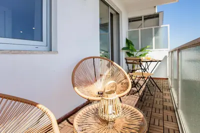 two chairs and a vase sitting on a balcony at Elegant Studio w/ AC & Balcony by LovelyStay in Porto
