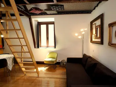 a living room with a staircase and a couch at Framer's House - Authentic Downtown in Porto