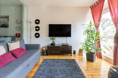 a living room with a couch and a flat screen tv at Sunny Oporto, Trindade Balcony in Porto