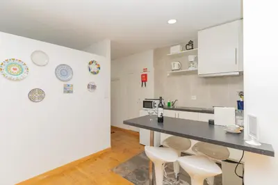 a kitchen with a counter and stools in a room at Sunny Oporto, Douro Apartments in Porto