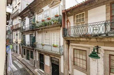 an alley with balconies and a green bell on a building at Sunny Oporto, Douro Apartments in Porto