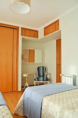 a bedroom with a bed and a blue chair at Musical View in Porto