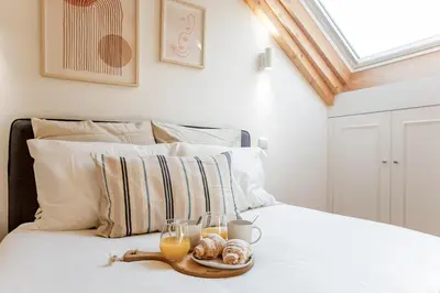 a bed with two glasses of orange juice and pastries on it at Bright 3BR Flat w/ AC in City Center by LovelyStay in Porto