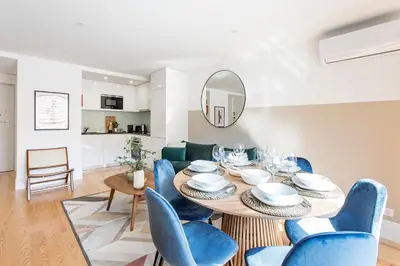 a dining room with a table and blue chairs at Bright 3BR Flat w/ AC in City Center by LovelyStay in Porto