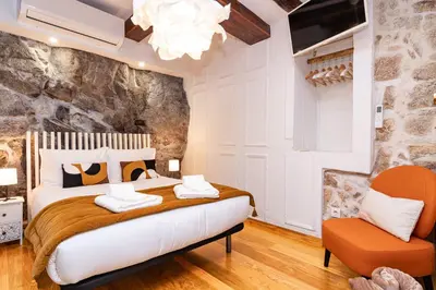 a bedroom with a large bed and a chair at Douro View House Ribeira in Porto
