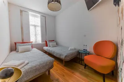 a small room with a bed and a chair at Douro View House Ribeira in Porto