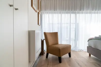 a bedroom with a chair and a bed and a window at Arty Porto in Porto