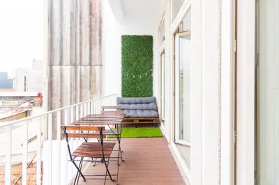 a balcony with chairs and a couch on it at ON Apartments - Lapa Deluxe in Porto